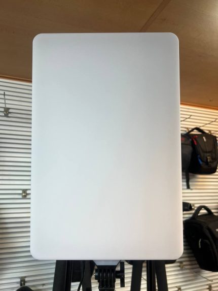 ور LED حرفه‌ای مدل C26 نصب‌شده روی سه‌پایه در یک استودیو عکاسی، در حال نورپردازی پرتره از یک مدل نشسته با نور نرم و یکنواخت.