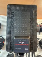 ور LED حرفه‌ای مدل C26 نصب‌شده روی سه‌پایه در یک استودیو عکاسی، در حال نورپردازی پرتره از یک مدل نشسته با نور نرم و یکنواخت.